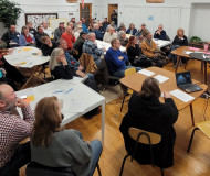 photo from a CO2 pipeline meeting in St. Ansgar showing nearly 50 people sitting around tables